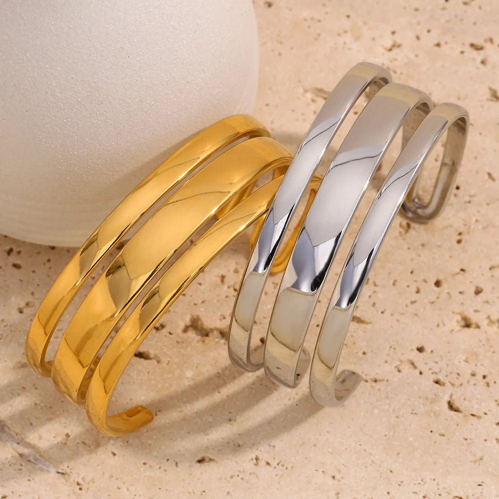 Gold and silver bangles on a textured beige surface