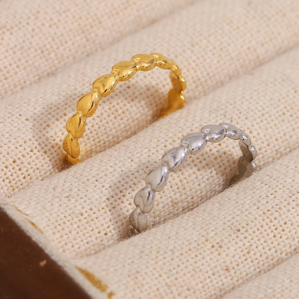 Gold and silver rings on a textured beige surface