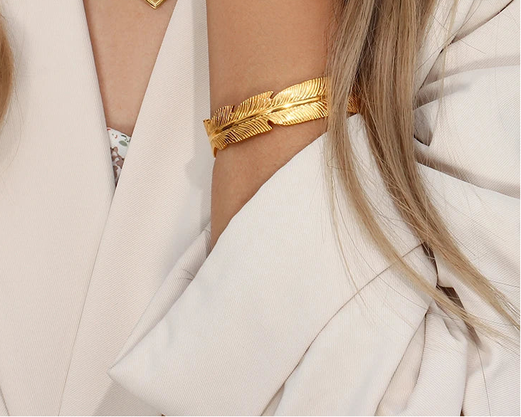 Gold bracelet on a person wearing a white outfit