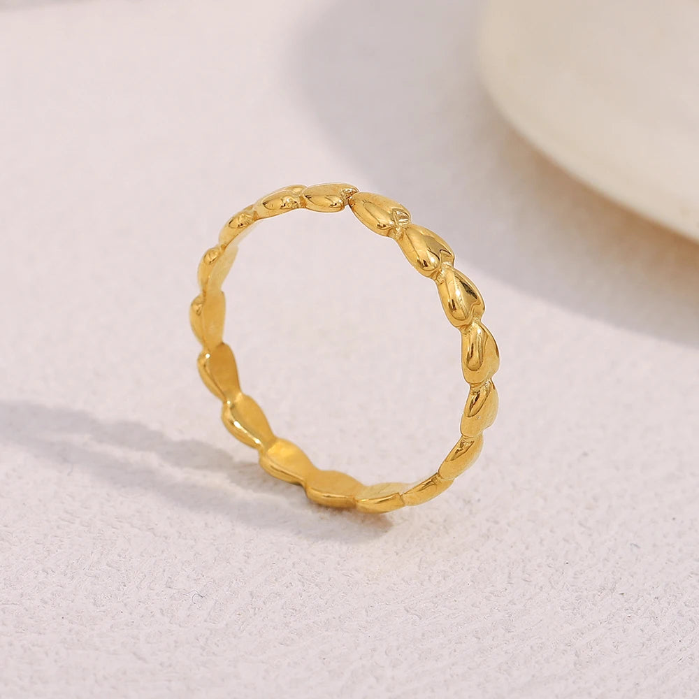 Gold ring with textured design on a light background