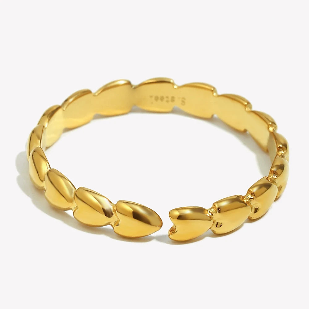Gold hearts linked ring with a textured design on a white background