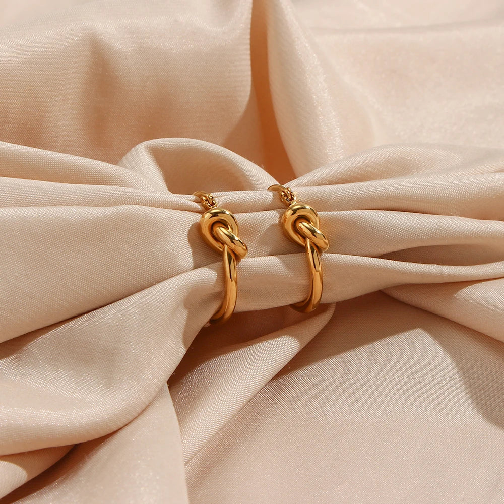 Gold hoop earrings on a beige fabric background