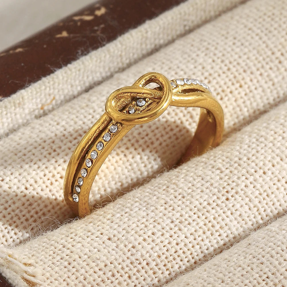 Gold ring with diamond accents on a textured beige surface