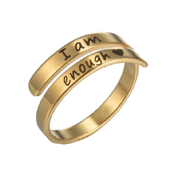 Gold ring with 'I am enough' engraving on a white background