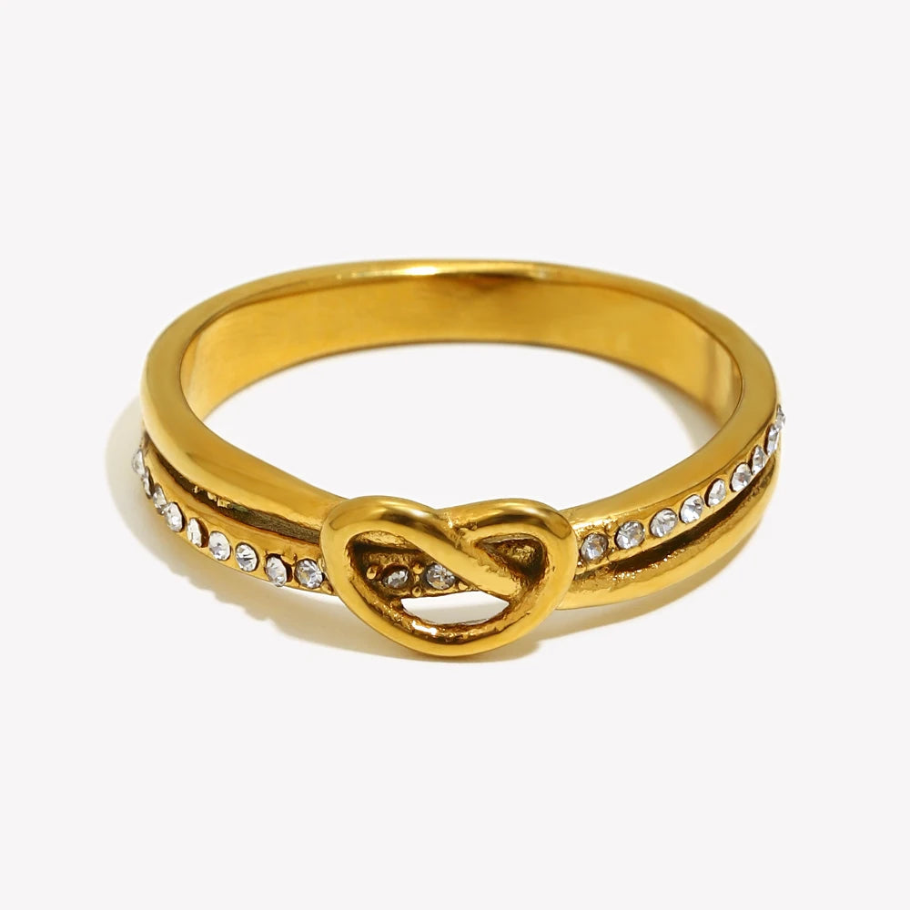 Gold ring with a knot design and small diamonds on a white background
