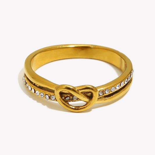 Gold ring with a knot design and small diamonds on a white background