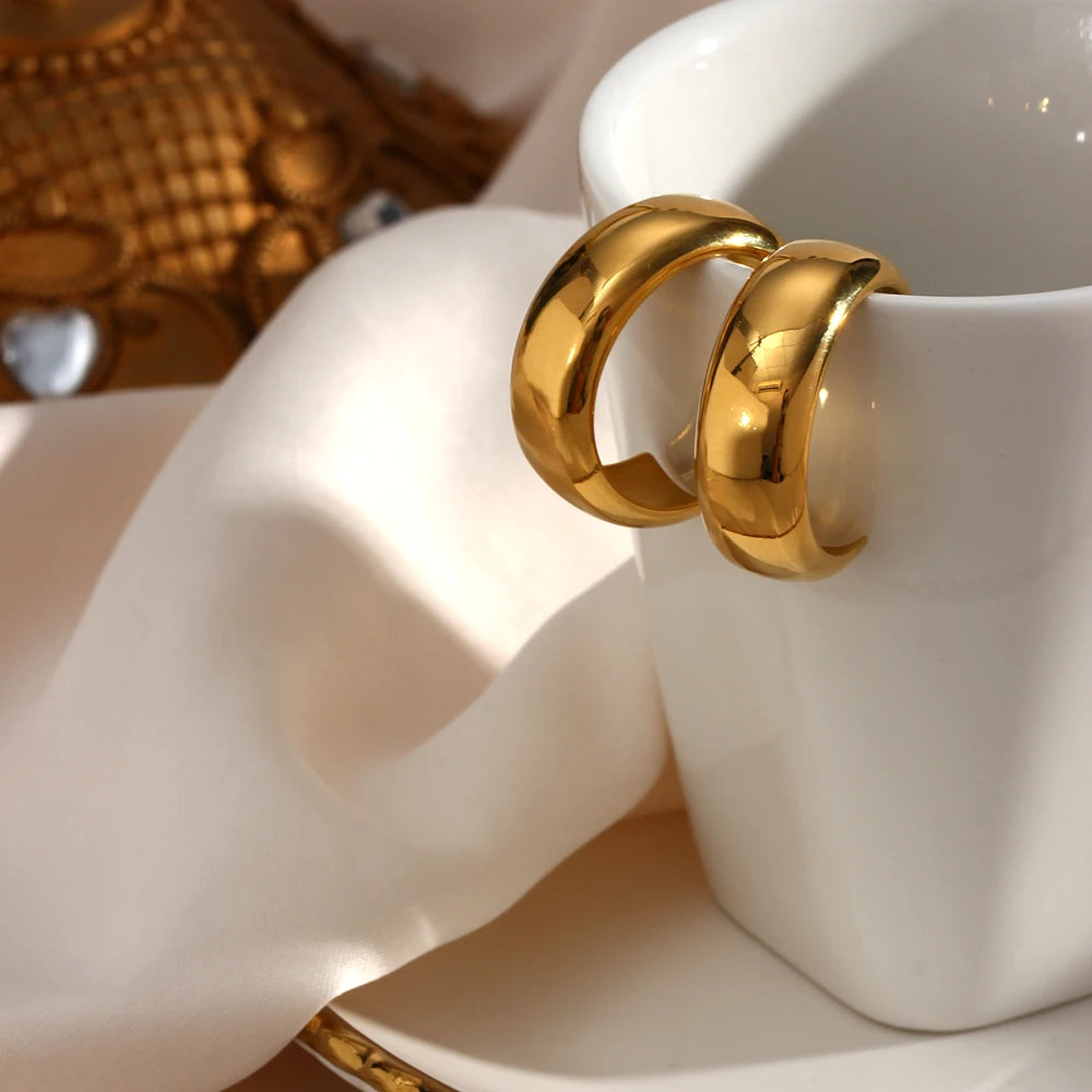 Gold rings on a white ceramic cup with a blurred background