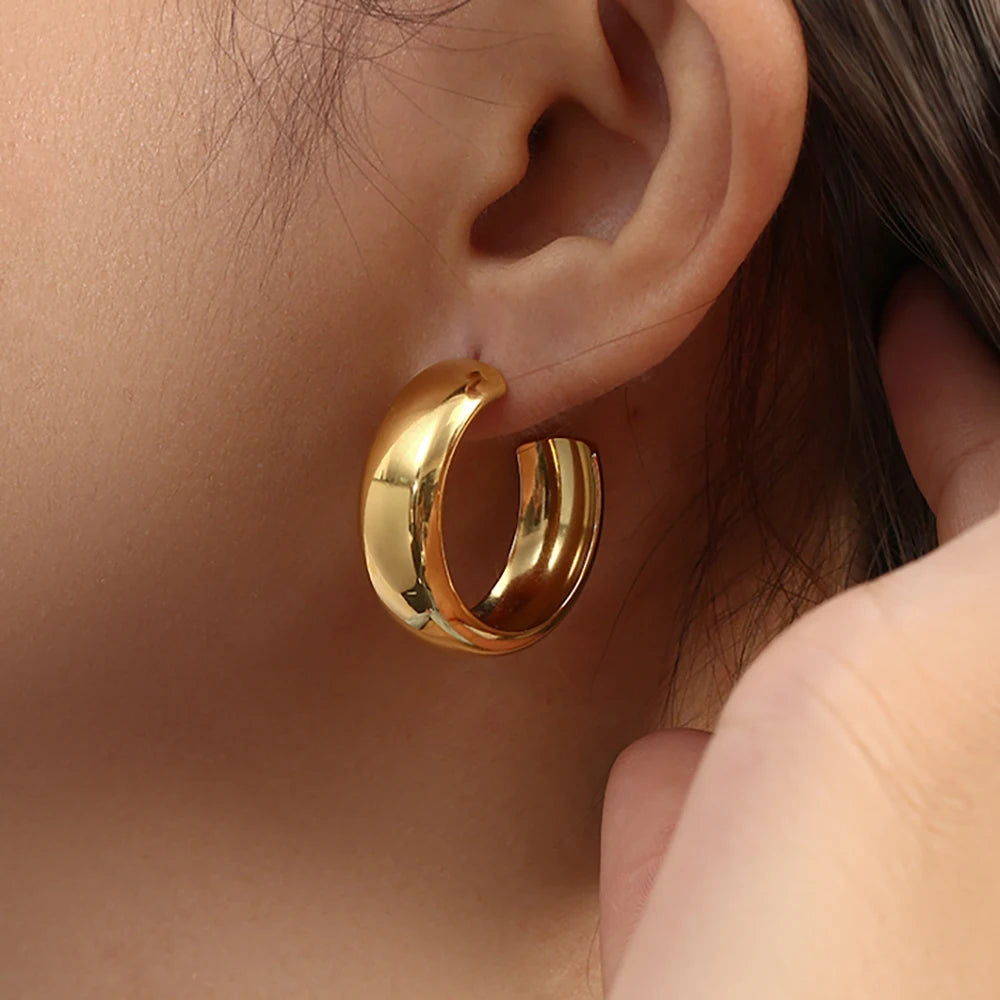 Gold hoop earring worn by a person