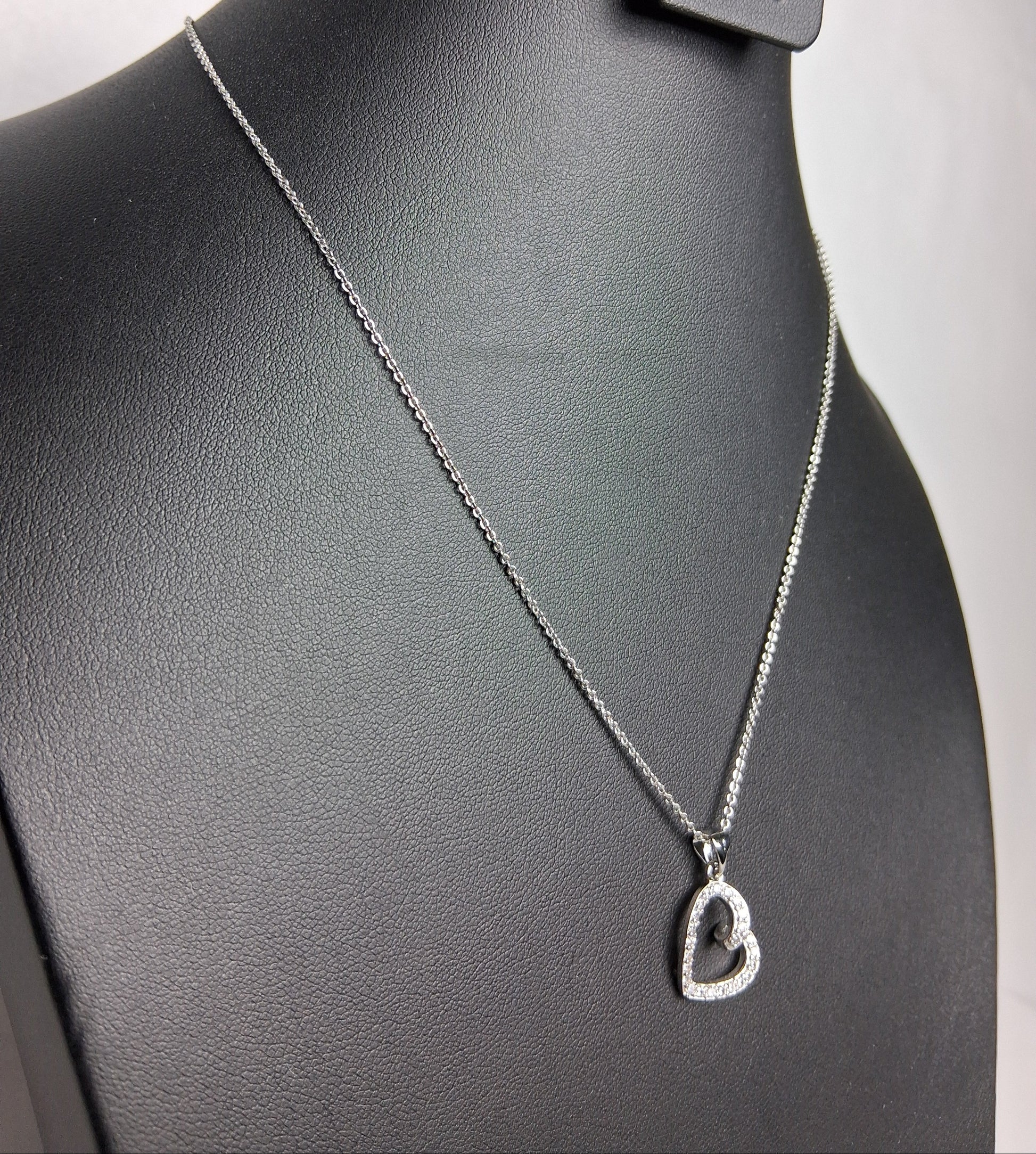 Necklace with a heart pendant on a black leather surface