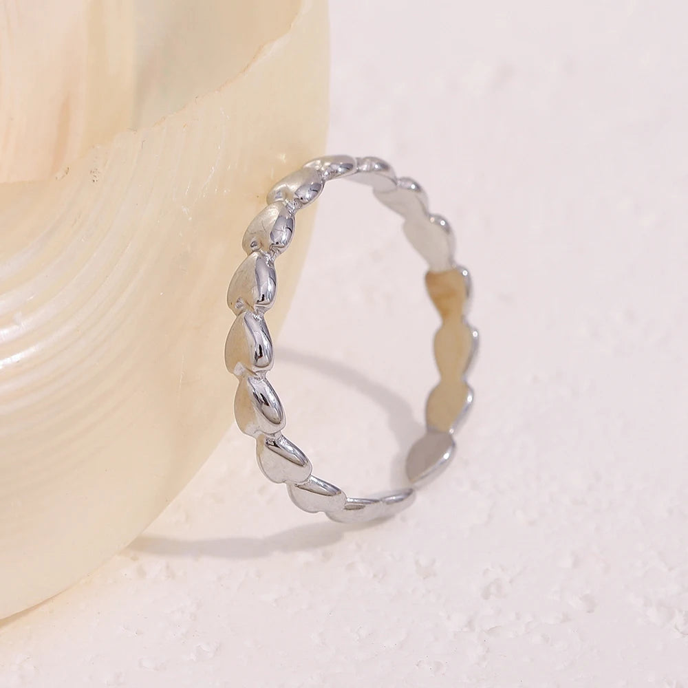 Silver ring with wavy design on a light beige background