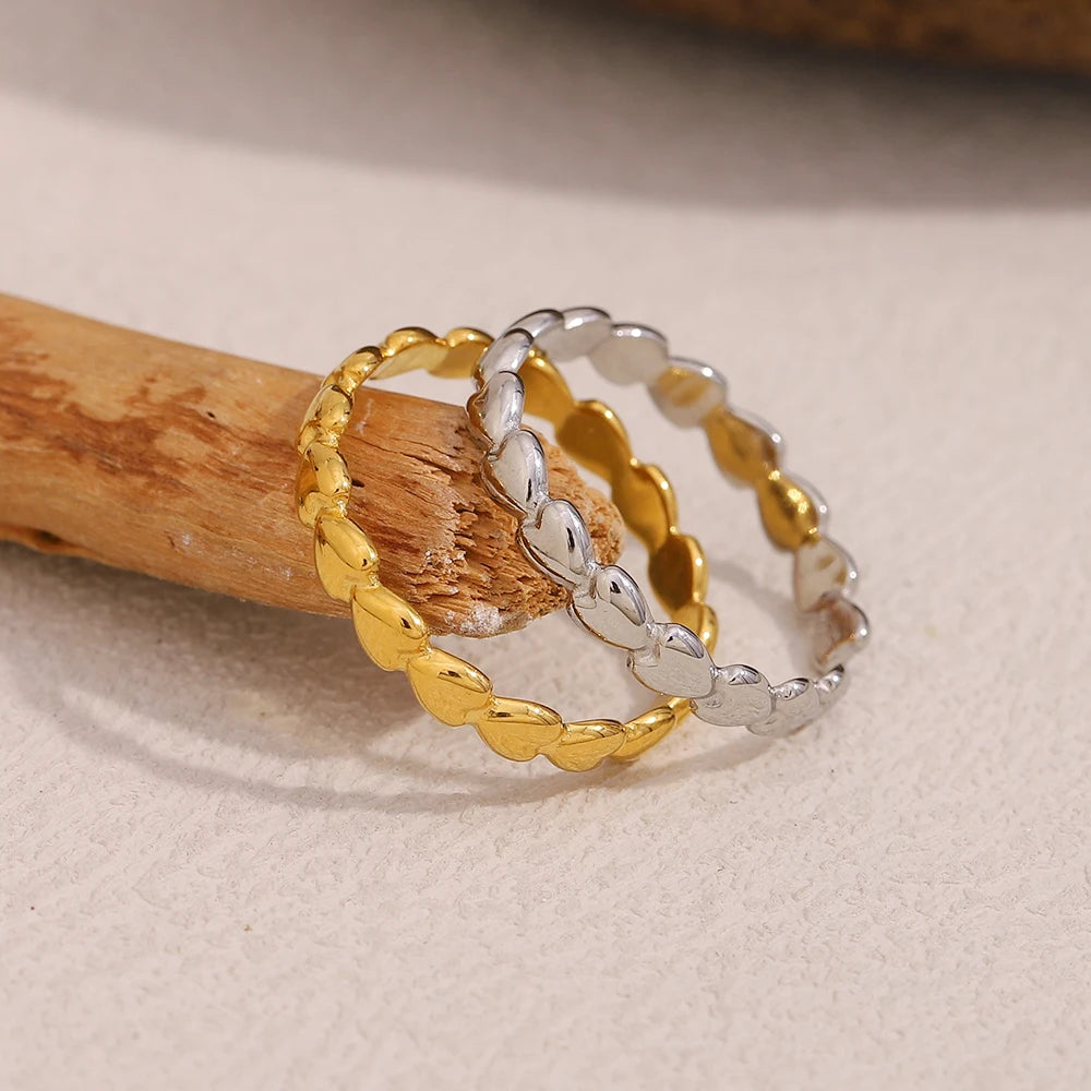 Two gold and silver rings on a wooden stick with a beige background