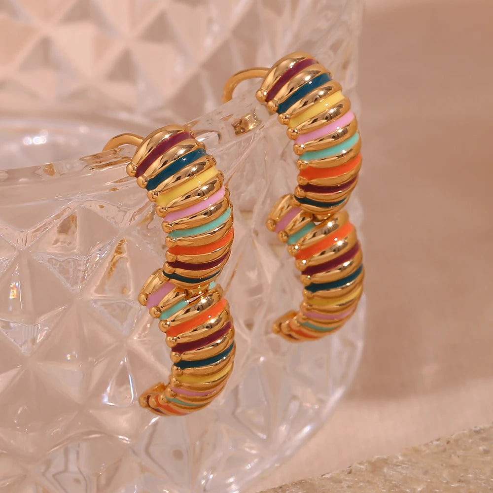 opened Colorful hoop earrings with gold accents on a textured surface