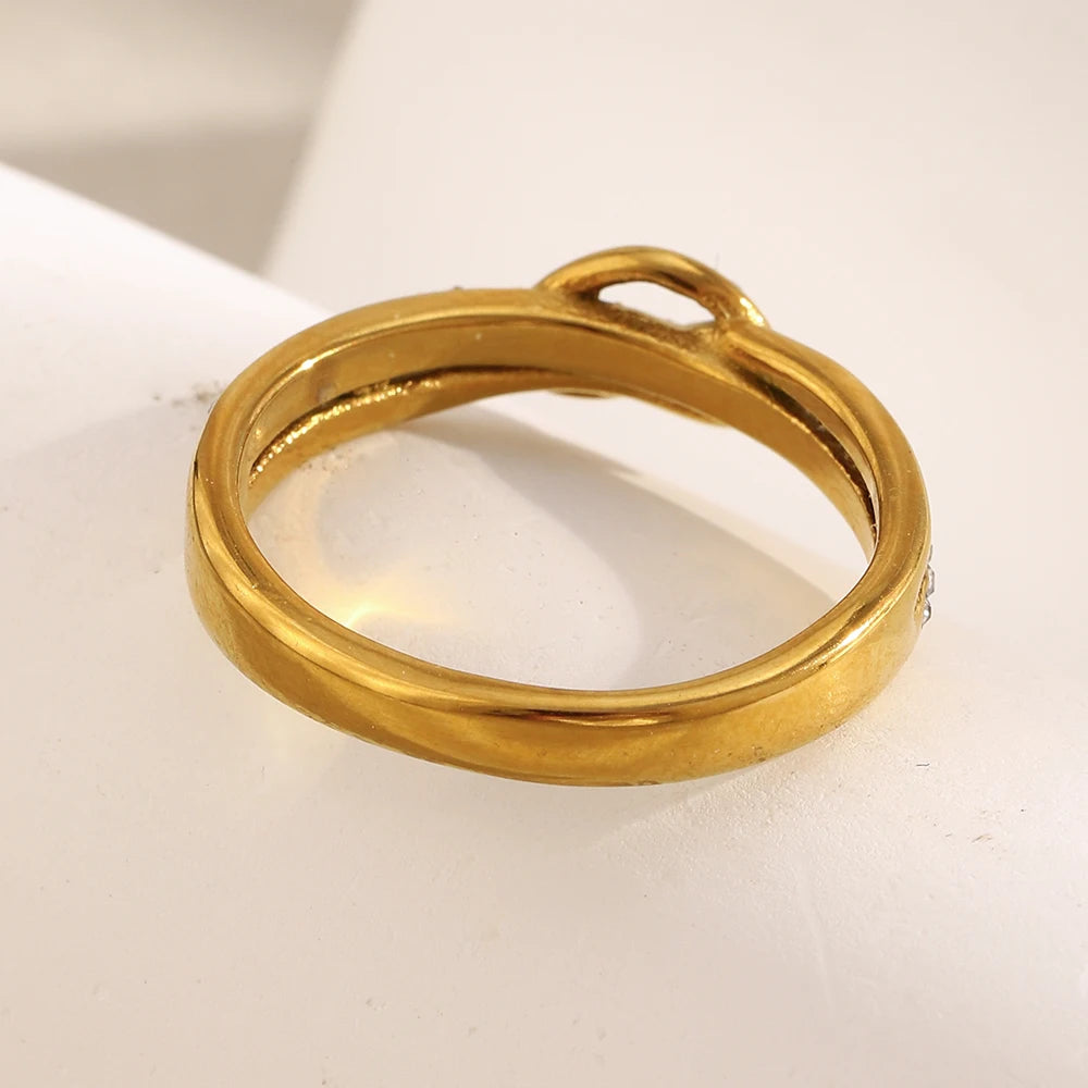 the back view of a Gold ring with a unique design on a light background