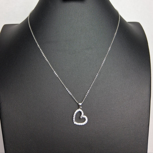 A white gold necklace with a heart-shaped pendant displayed on a black mannequin bust.